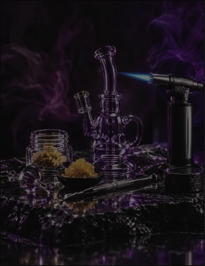 Glass dab rig and torch beside jars of concentrate