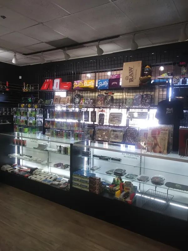 Lit glass counters and a wall of rolling trays, papers and accessories